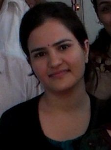 Portrait of Dr. Kapoor wearing traditional attire with academic books in background